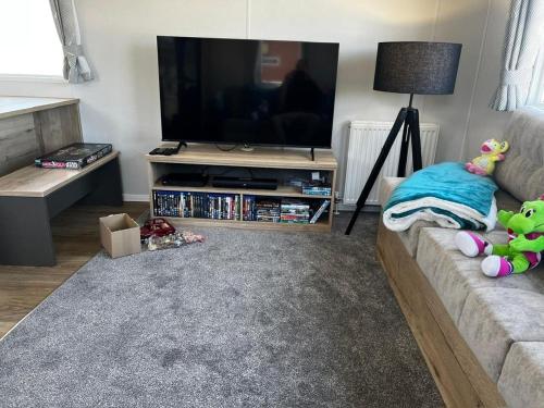a living room with a couch and a flat screen tv at SBL57 - Parkdean, Camber Sands in Camber