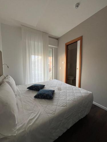 a bedroom with a large bed with two pillows on it at Hotel Mayer in Lido di Jesolo