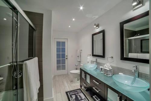 a bathroom with two sinks and a toilet and a mirror at Villa Camelot - Gulf Access in Shell Point Village