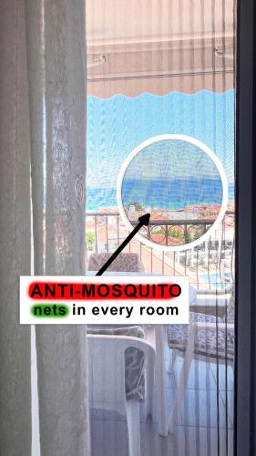 a room with a window with a table and a chair at Rona Vista Suites amazing seaview 2 in Polykhrono