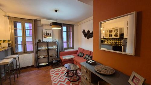 a living room with a red couch and a table at Au coeur de Collioure in Collioure