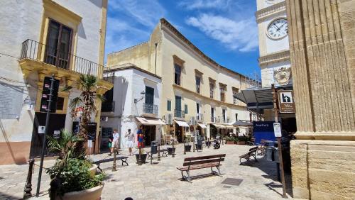 a street with a clock tower in a city at CASA ELAIO - immersa negli ulivi con vista sul mare Ionio in Marina San Gregorio