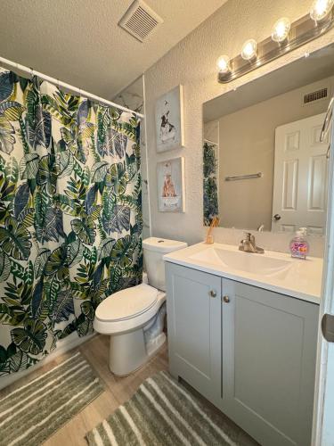 a bathroom with a toilet and a sink and a mirror at 1 DT Dallas l FIFA READY l Staycation 1Bd1Ba in Dallas