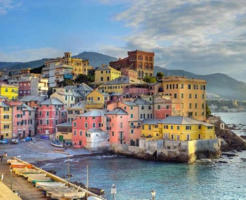un grupo de casas coloridas en una colina junto al agua en Welcome in Genova, en Génova