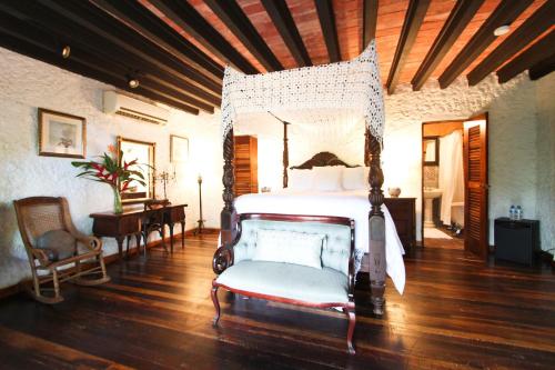 a bedroom with a canopy bed and a chair at Hacienda Siesta Alegre in Rio Grande