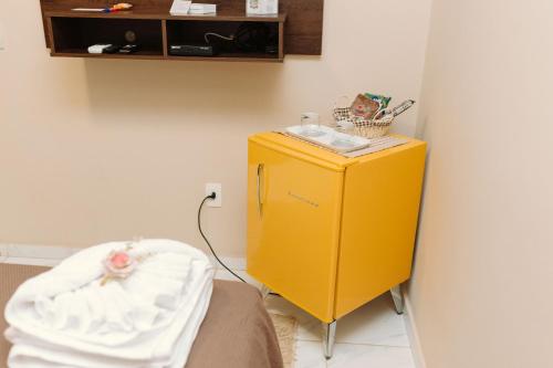 a yellow cabinet in a room with a bed at Casa da Coruja in Rio de Janeiro