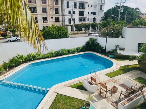 a large swimming pool in a yard next to a building at Beautiful 2 bedroom house with pool at best location in Cancún
