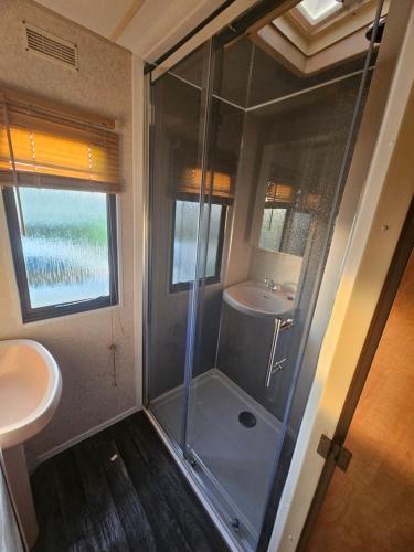 a bathroom with a shower and a sink at Beckys Holiday Van in Ingoldmells