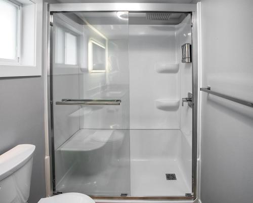 a shower with a glass door in a bathroom at Parkside Pet Friendly Bungalow in Winona