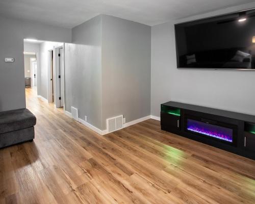a living room with a television and a wooden floor at Parkside Pet Friendly Bungalow in Winona