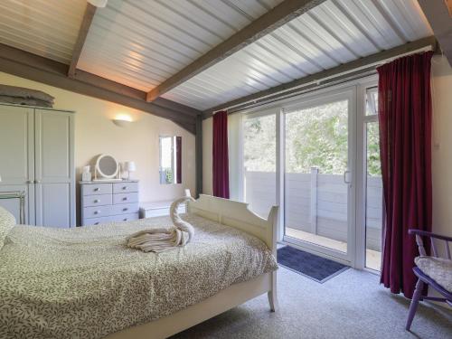 ein Schlafzimmer mit einem Bett und einem großen Fenster in der Unterkunft Brookfield Lodge in Burstock