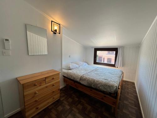 une petite chambre avec un lit et une commode en bois dans l'établissement Villa climatisée, 4 couchages, 2 chambres, véranda, Résidence LES TAMARIS, accès payant pour les piscines, wifi, PORTIRAGNES PLAGE LRTAML9, à Portiragnes