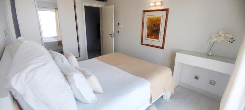 a bedroom with a bed with white sheets and pillows at Casa do Mar - Luxurious Villa with Swim Spa & sea view in Luz