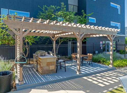 a wooden pergola with a grill and a table and chairs at Cozy 1B1B with Pool, Parking, WiFi, Gym 30mnts from Austin in Cedar Park