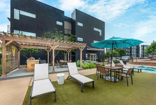 a patio with a table and chairs and an umbrella at Cozy 1B1B with Pool, Parking, WiFi, Gym 30mnts from Austin in Cedar Park