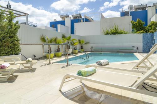 a patio with a pool and lounge chairs at LV Premier Algarve FU1- pool, AC, garden, sea view in Moncarapacho
