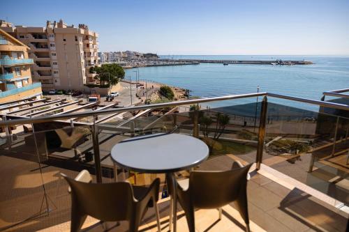 a balcony with a table and chairs and the ocean at Hotel Flamingo in L'Ampolla