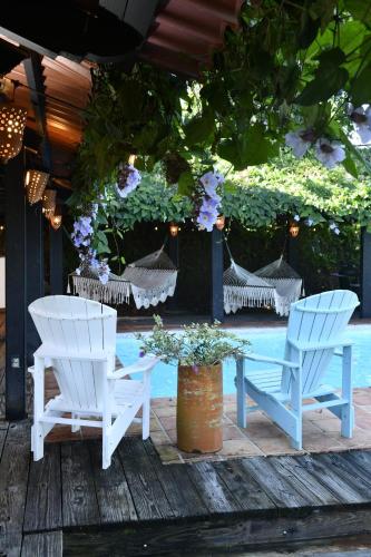 a couple of chairs and a table and some flowers at Hacienda Siesta Alegre in Rio Grande