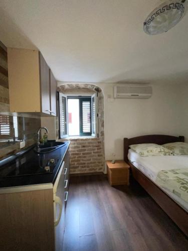 eine Küche mit Bett und Waschbecken in einem Zimmer in der Unterkunft sar 5 in Kotor