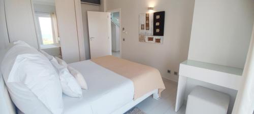 a white bedroom with a white bed and a window at Casa do Mar - Luxurious Villa with Swim Spa & sea view in Luz