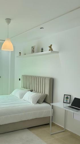 a bedroom with a bed and a table and a laptop at Karim Palace ,Five Stars Quality With Low Budget, Near The Beach And Airport in Tangier