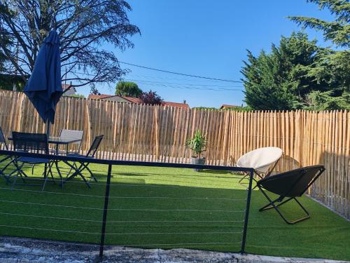 a table and chairs and an umbrella in a yard at Gîte Drôme des collines in Anneyron