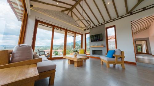 ein Wohnzimmer mit Sofa, Stühlen und Fenstern in der Unterkunft CasaBlanca1 in Villa de Leyva