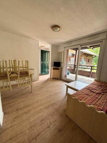 une chambre avec un lit, une table et des chaises dans l'établissement Résidence Les Chalets de Puy Saint Vincent - maeva Home - Appartement 2 Pièces 4 Personnes - Confort MAE-6369, à Narreyroux