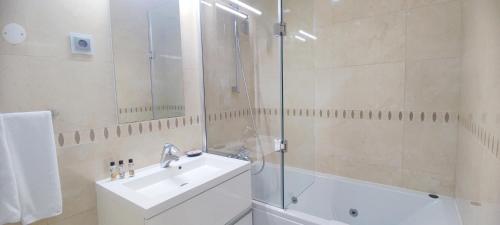 a bathroom with a shower and a sink and a tub at Casa do Mar - Luxurious Villa with Swim Spa & sea view in Luz