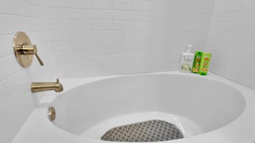 a bathroom with a white tub with a sink at LUX 1B1B with Parking, Pool, Gym, Private Patio near Austin in Cedar Park