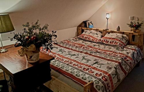 a bedroom with a bed and a table with a bedspread at Gospodarstwo agroturystyczne Ryznerówka in Posada Rybotycka
