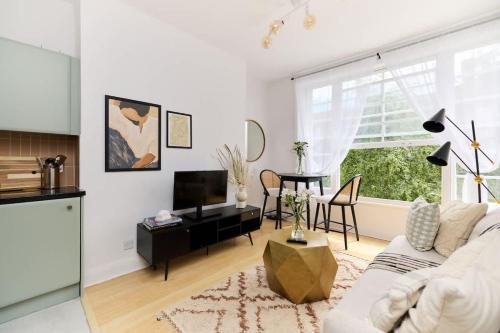 a living room with a white couch and a table at The Camden Hideout - Modish and Bright 2BDR Flat in London