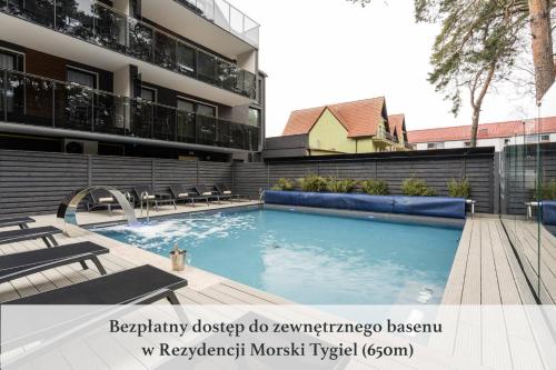 a swimming pool in front of a building at Boulevard Boutique Suites in Łeba