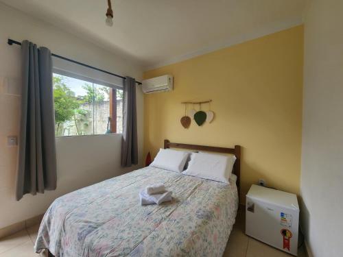 a bedroom with a large bed with a window at Pousada Sertão in Alto Paraíso de Goiás