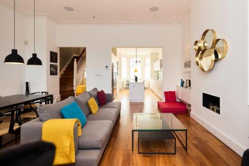 een woonkamer met een bank en een tafel bij The Clapham Crib - Spacious 4BDR House with Patio in Londen