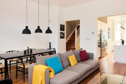 een woonkamer met een bank en een tafel bij The Clapham Crib - Spacious 4BDR House with Patio in Londen