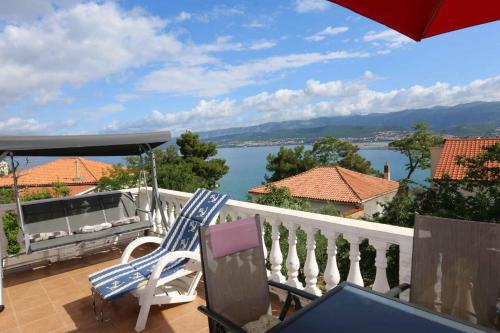 taras z krzesłem i parasolem oraz widokiem na wodę w obiekcie Apartment in Silo - Insel Krk 13554 w mieście Šilo