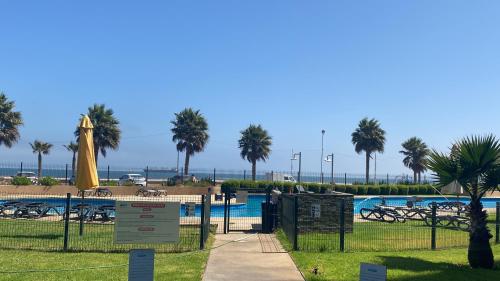 a resort with a pool and a beach with palm trees at Departamento encantador en una ciudad maravillosa in Coquimbo
