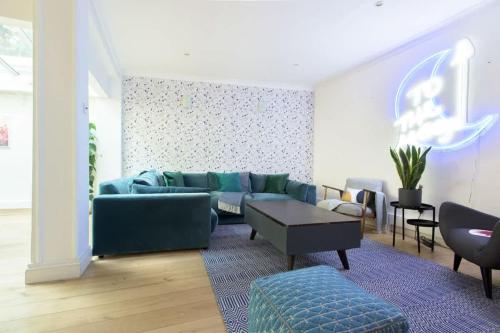 a living room with a blue couch and a table at The Harrods Mews - Modern 4BDR with Rooftop Terrace in London