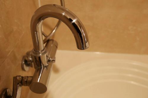 a silver faucet on the side of a bath tub at Hotel Cullinan Yongin in Yongin
