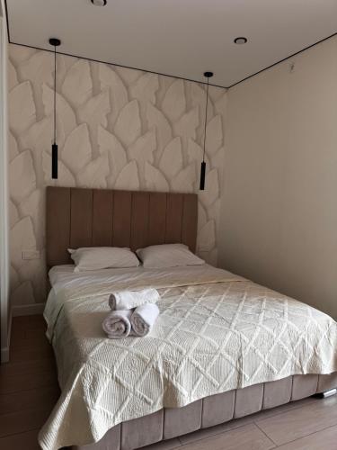 a bedroom with a bed with towels on it at Апартаменты по суточно in Zhezdi