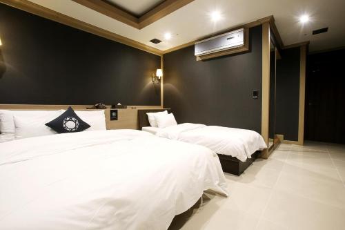 a bedroom with two beds and a air conditioner at Hotel Cullinan Yongin in Yongin