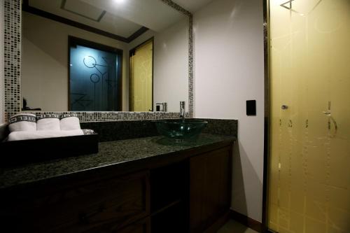 a bathroom with a sink and a large mirror at Hotel Cullinan Yongin in Yongin