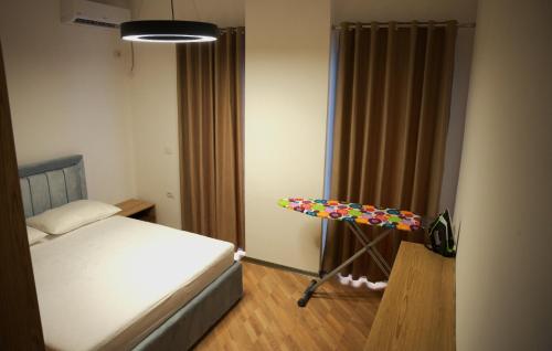 a bedroom with a bed and a table in it at Duo Lux Golem Apartment in Golem