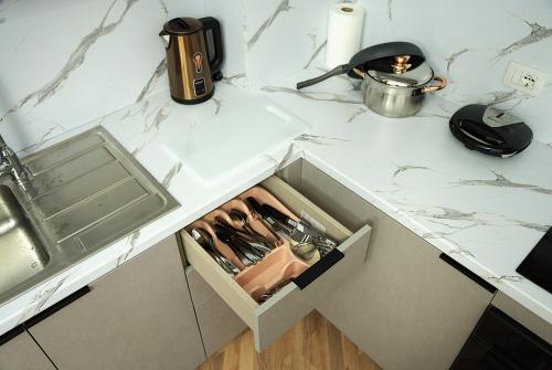 a white counter top with a drawer in a kitchen at Duo Lux Golem Apartment in Golem