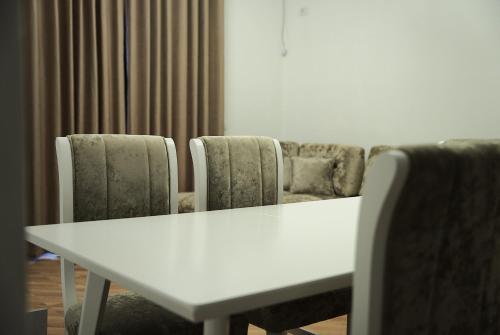 a white table and chairs in a room at Duo Lux Golem Apartment in Golem