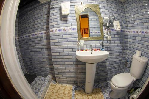 a bathroom with a sink and a toilet and a mirror at Riad Shauala Fez in Fès