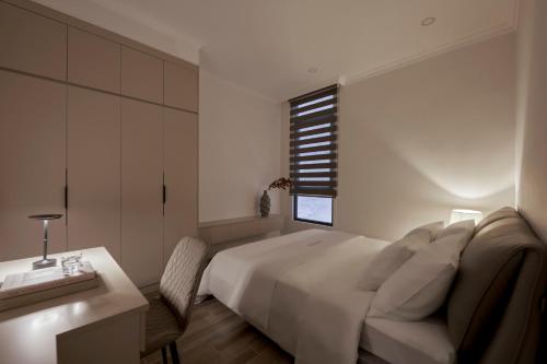 a bedroom with a bed and a desk and a window at Hoang Dung Hotel and Apartment by THC Group in Thuan An