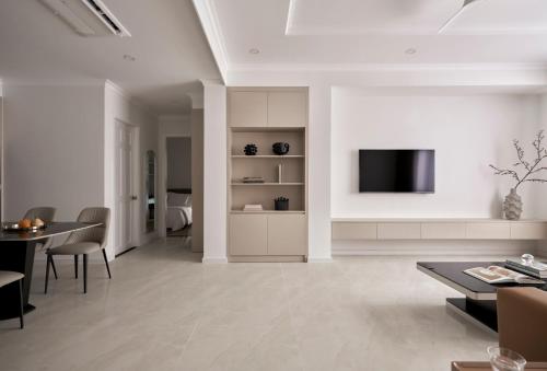a living room with a table and a tv on a wall at Hoang Dung Hotel and Apartment by THC Group in Thuan An