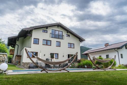 a large white house with two hammocks in front of it at Landhaus Flasch in Wagrain